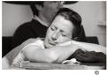  Fotografie Menschen Eine Frau , die den Kopf mit geschlossenen Augen auf ihre verschränkten Arme gelegt hat.