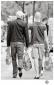  Fotografie Menschen Zwei Männer in Rückenansicht,  mit Einkaufstaschen beladen, die sich zärtlich an den Händen berühren.